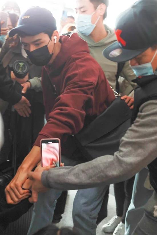 ?3月13日在北京机场，龚俊扶起因过于拥挤而摔倒的粉丝（图源：视觉中国）